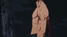 a man with no shirt on standing in the dark