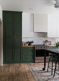 a kitchen with green cabinets and wooden floors