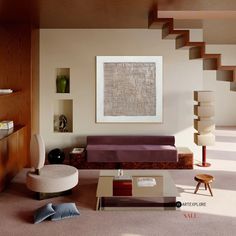 a living room filled with furniture and a painting on the wall above it's coffee table