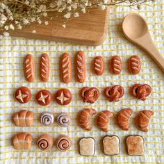 hotdogs and buns are arranged on a towel next to a wooden spoon