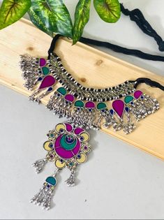 A piece of handmade boho jewellery never fails to amplify a woman's beauty and social confidence. This multicolour bib choker necklace is made with the finest materials and has high-quality silver plating to ensure a long-lasting product life. If you wish to style it every now and then, we advise you to clean the jewellery with a cotton cloth and store it in an air- tight container away from any chemicals or water. This boho tribal necklace is made of glass, perfect to fit in the collection of B Adjustable Multicolor Bohemian Jewelry, Artistic Festival Jewelry, Multicolor Oxidized Finish Necklace For Festive Occasions, Adjustable Multicolor Artistic Design Necklaces, Festive Multicolor Artisan Necklaces, Green Bohemian Necklace With Oxidized Finish, Bohemian Multicolor Long Necklace, Adjustable Necklaces With Latkans For Gifts, Festive Multicolor Necklace With Oxidized Finish