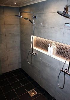 a bathroom with tiled walls and flooring has a shower head next to the toilet