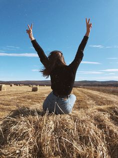 a woman sitting on top of a dry grass field