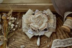 a bouquet of flowers sitting on top of a wooden table next to lace and buttons