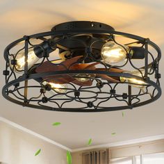 a ceiling light that is hanging from the ceiling in a room with green leaves on it