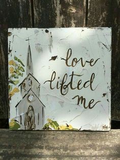 a sign that says love lifted me with a church in the background and leaves on it