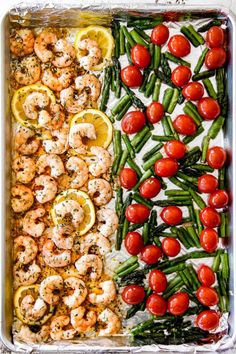 sheet pan shrimp scampp with tomatoes, green beans and lemons on top