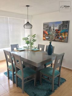 a dining room table and chairs with blue rugs