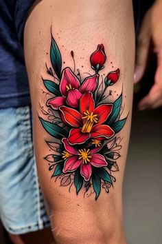 a woman's thigh with flowers and leaves tattooed on her leg, while she is wearing