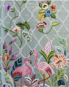 an embroidered fabric with flamingos and flowers on it