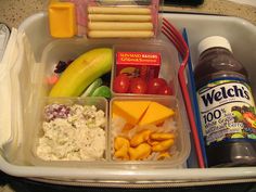 a plastic container filled with lots of food and condiments on top of a table