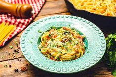 a plate of pasta with sauce and parmesan cheese on it next to other food