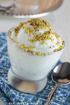 there is a dessert with whipped cream and pistachio sprinkles