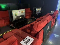 red couches are lined up in front of televisions