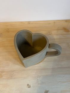 a heart shaped cup sitting on top of a wooden table