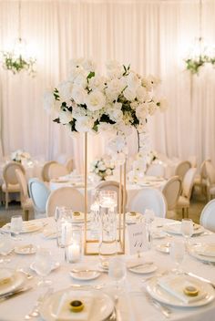 a table set up with white flowers and candles for an elegant wedding reception at the four seasons resort