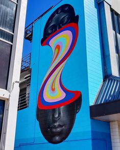 a blue building with a large painting on it's side