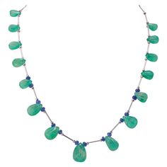 This special piece will never go out of style and will make you feel more gorgeous. From the boardroom to the ballroom, this necklace will make heads turn! This necklace is around 21 inches long. Stone Details: Emerald Carving Drop: 75.32 Carats Tanzanite Beads: 6.54 Carats 18K White Gold Luxury Round Emerald Necklace With Gemstone Beads, Zelda Au, Tanzanite Beads, Art Deco Emerald, Necklace Art Deco, Tanzanite Necklace, Beaded Necklace Patterns, Elegant Jewellery, Necklace Art