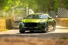 a green car driving down a country road