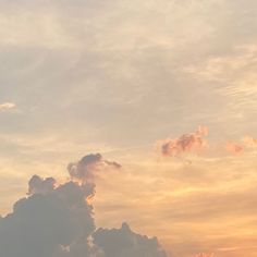 the airplane is flying high in the sky at sunset or dawn with clouds and sunbeams behind it