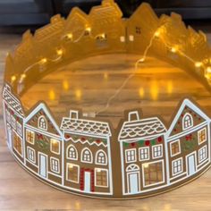 a close up of a paper crown on a wooden floor with lights in the background