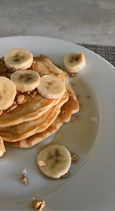 a stack of pancakes with bananas and nuts on top