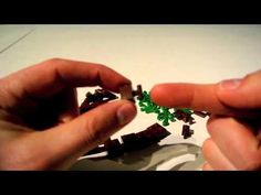 two hands holding small pieces of green legos