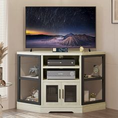 a flat screen tv sitting on top of a wooden stand