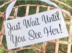 a sign that says, just wait until you see her on an old rusty chair