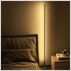 a lamp that is on top of a bed next to a night stand and nightstand