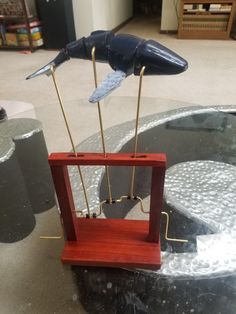 two birds are sitting on top of an object in the shape of a pendulum wheel