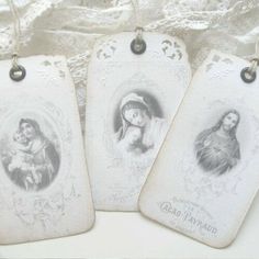 three tags with pictures of the virgin mary and baby jesus are hanging on a white background