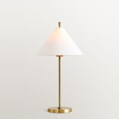 a lamp with a white shade on top of it and a gold base, against a white background