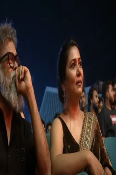 a man and woman sitting next to each other in front of an audience at a movie theater