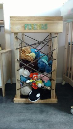 a wooden crate filled with lots of stuffed animals on top of carpeted flooring