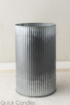 a metal cup sitting on top of a white counter next to a window sill