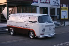 an old vw bus parked on the side of the road in front of a building