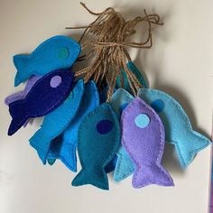 five felt fish hanging from a string on a table