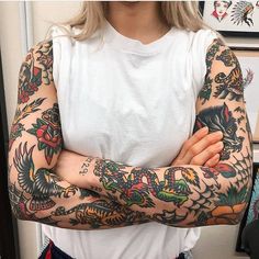 a woman with tattoos on her arms posing for the camera