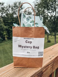 a brown paper bag sitting on top of a wooden fence