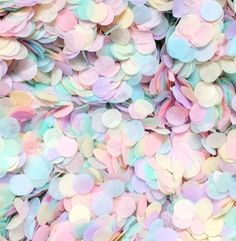 pastel colored confetti sprinkles are scattered on top of each other