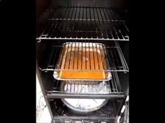 an oven with food cooking in it and the grill door open to show what is inside