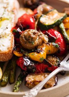 a white plate topped with grilled vegetables and bread