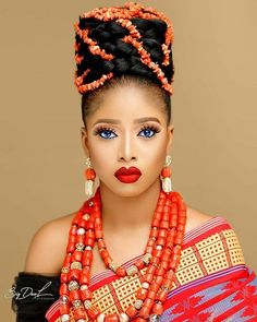 an african woman with blue eyes and red lipstick, wearing orange beads on her head