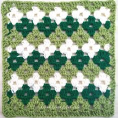 a green and white crocheted afghan is shown