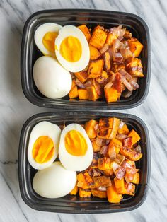 two trays filled with eggs and bacon on top of a marble countertop next to each other