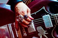 a person holding onto a guitar with their fingers