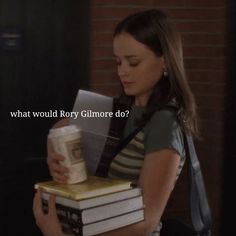 a girl is holding some books and looking at the book in her hand that says, what would roxy gimore do?