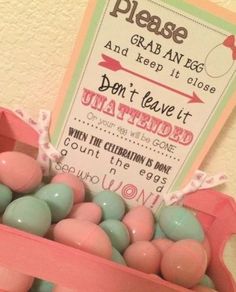 a pink box filled with lots of candy next to a sign that says please grab an egg and keep it close don't leave it unattened