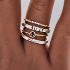 The Athena Ring Set offers a timeless combination of classic elegance and fine craftsmanship. Crafted from pure silver and 14K yellow gold filled, the set includes a 4mm gray cz stone and a custom-made name ring in both uppercase skinny font and l... Elegant Silver Initial Ring With Birthstone, Elegant Everyday Rings With Custom Name, Elegant Custom Name Ring For Everyday, Elegant Custom Name Rings For Everyday, Elegant Custom Name Ring, Elegant Yellow Gold Stackable Rings With Custom Name, Silver 14k Gold Engraved Ring With Birthstone, Elegant Silver Customizable Stackable Rings, Elegant Customizable Silver Stackable Rings